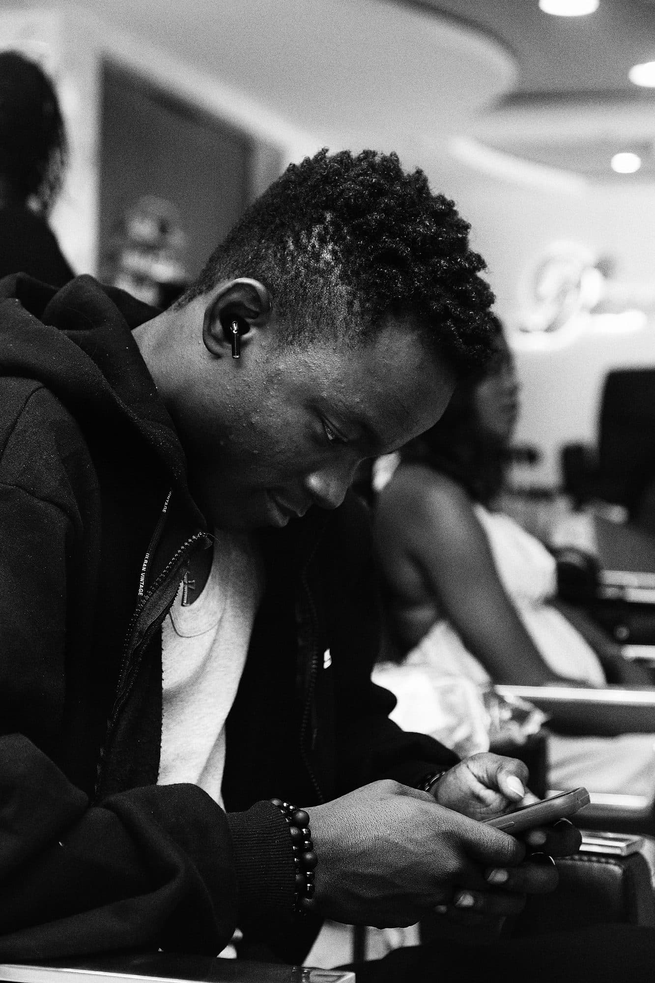 A young man alone, looking at his phone