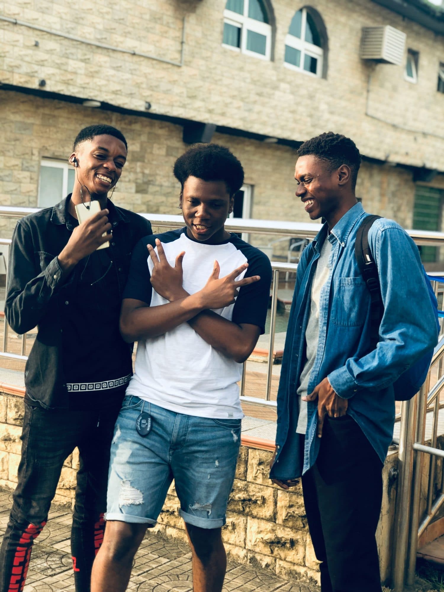 Three young men talking outside a university building