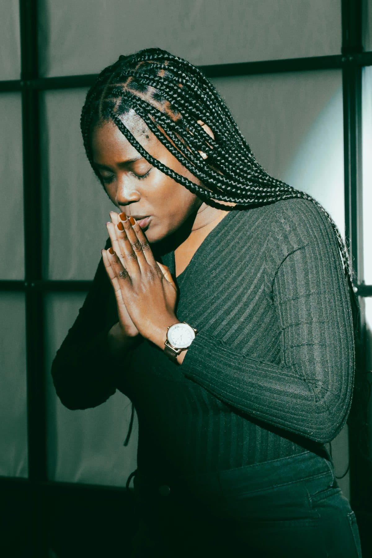 A young woman praying with folded hands